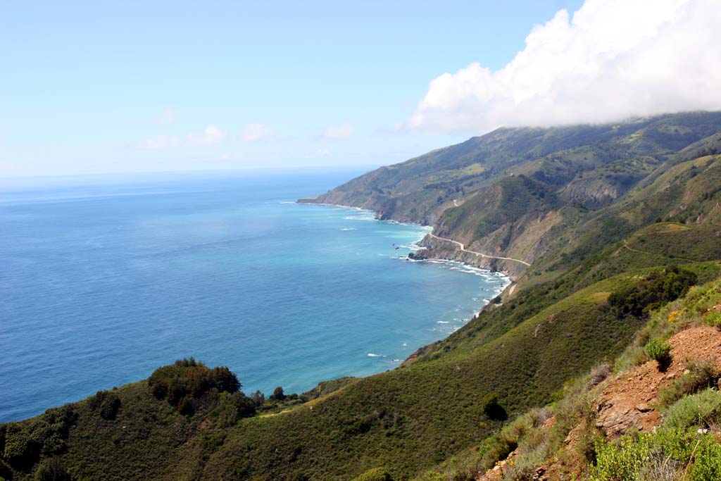 A scenic view of a coastline with mountains and ocean.